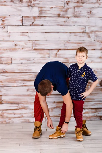 Vater bindet Schnürsenkel an die Schuhe des Sohnes — Stockfoto