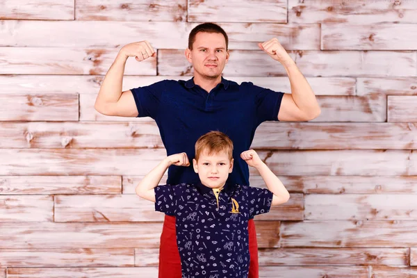 Молодой отец и восьмилетний сын демонстрируют силу мускулов. стильный мужчина и мальчик — стоковое фото
