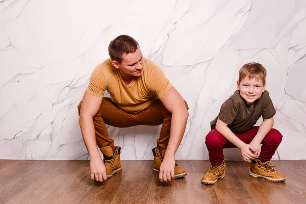 Um jovem moderno e um menino alegre de oito anos de idade em sapatos laranja. dia do pai — Fotografia de Stock