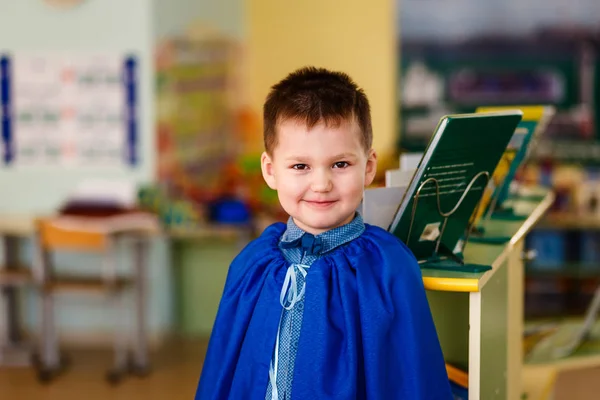 Усміхнена п'ятирічна дитина на розмитому фоні дитячого садка — стокове фото