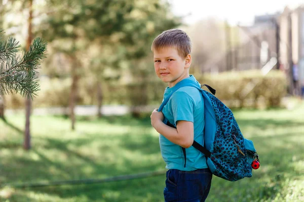 8-летний кавказский спортсмен с рюкзаком на спине смотрит в камеру — стоковое фото