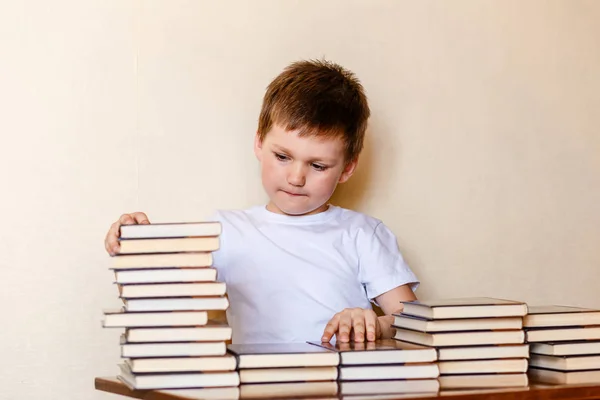 귀여운 여섯 살 짜리 소년과 많은 책. 읽기 배우기. — 스톡 사진