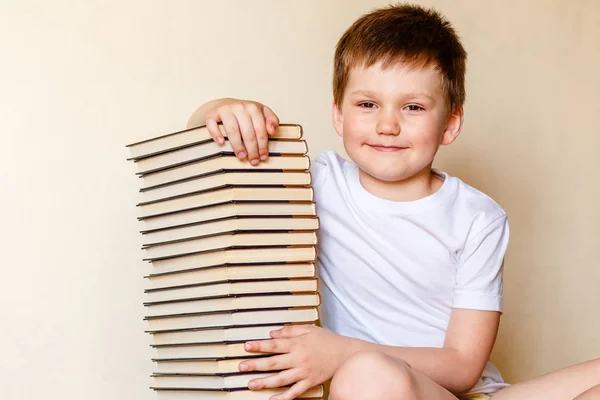 Улыбающийся ребенок и много книг — стоковое фото