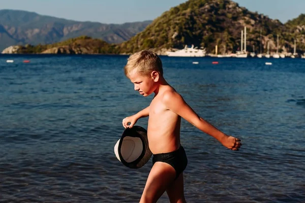 Загорелый мальчик в море летом — стоковое фото