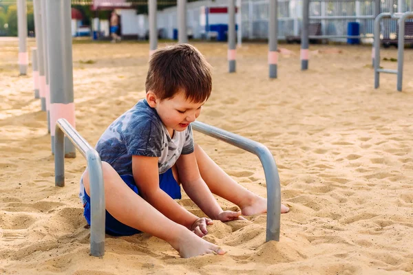 Пятилетний мальчик играет с песком — стоковое фото