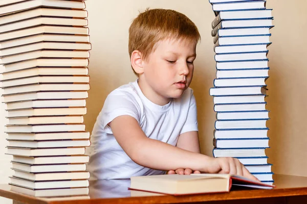 Ośmioletni chłopiec czyta książkę, śledzą linię palcem. dziecko uczy się czytać. — Zdjęcie stockowe