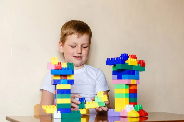 Seven-year-old child playing with large parts of the designer — Stock Photo, Image