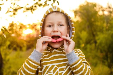 sarı kapüşonlu yedi yaşındaki bir çocuk bir bea kurabiye ısırır