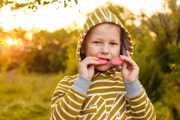 Семилетний ребенок в желтой толстовке кусает печенье в сумме — стоковое фото