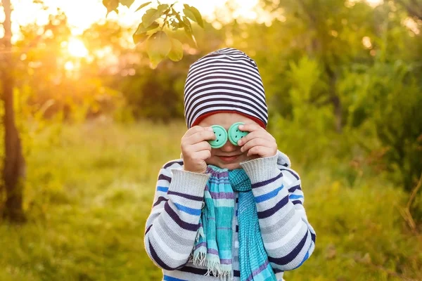 Пятилетний мальчик в полосатой шляпе и голубом шарфе закрывает свой — стоковое фото