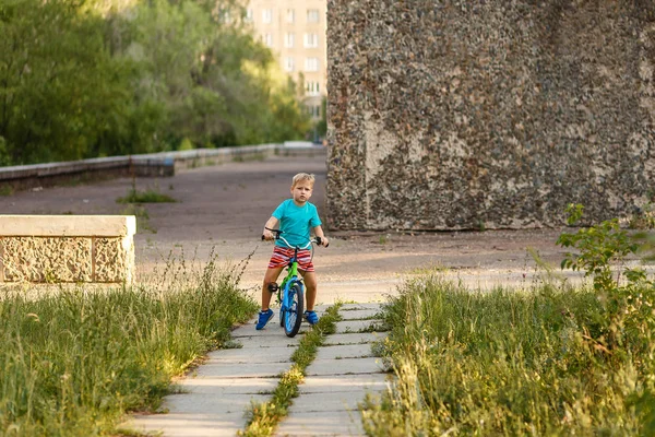 Serious seven-year-old boy riding a bike in the city Park — Stock Photo, Image