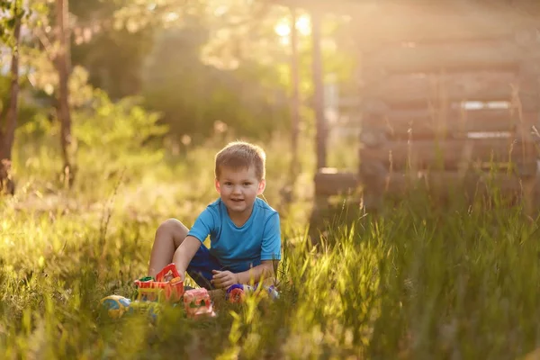 Милый пятилетний мальчик в голубой футболке и в шортах, играющий с — стоковое фото
