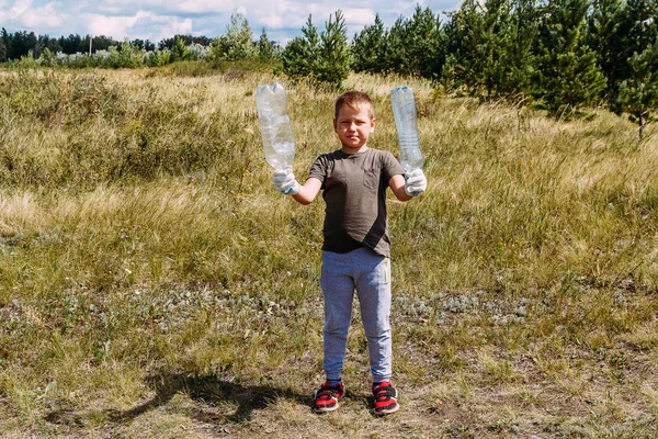 Вісім років хлопчик працює рукавички видаляє пластикові сміттєві шоу порожні пластикові пляшки — стокове фото
