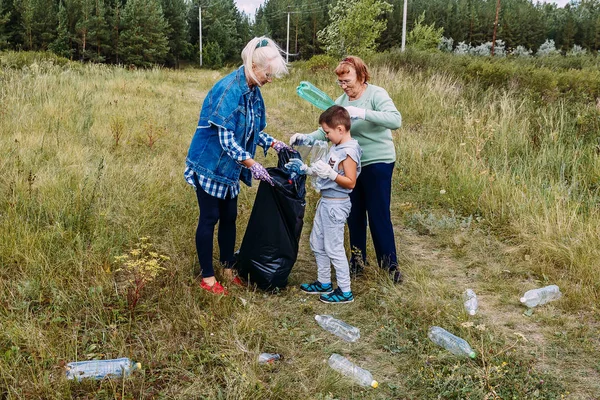 Люди убирают пластиковый мусор в лесу — стоковое фото