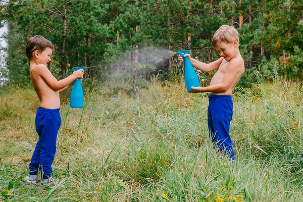 Dos chicos alegres salpicando agua en el calor del verano —  Fotos de Stock