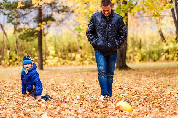 Boy and dad kick ball