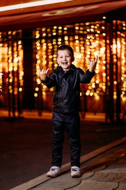 şehir ışıkları arka planda siyah deri ceket ve pantolon duygusal beş yaşındaki çocuk