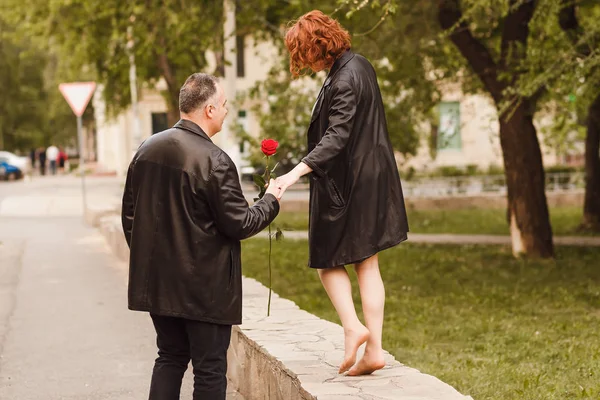 Kırk yaşında bir adam dışarıda bir kadının elini tutuyor. orta yaşlı çift — Stok fotoğraf