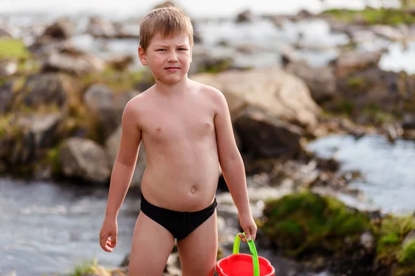 Семилетний спортивный мальчик только в плавках на реке — стоковое фото