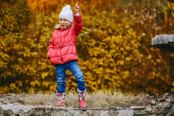 Alegre niña de cinco años en chaqueta de color rosa cálido y jeans en pleno crecimiento otoño. chica posando —  Fotos de Stock