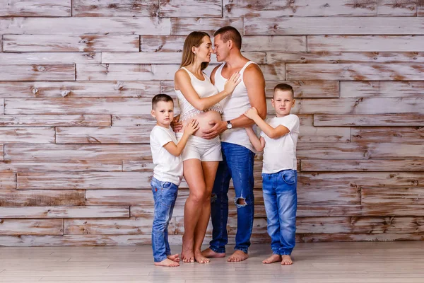 Dos chicos en jeans, un padre y una madre embarazada. familia joven —  Fotos de Stock