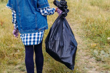 Bir gönüllü kadının elinde büyük siyah bir çöp torbası.