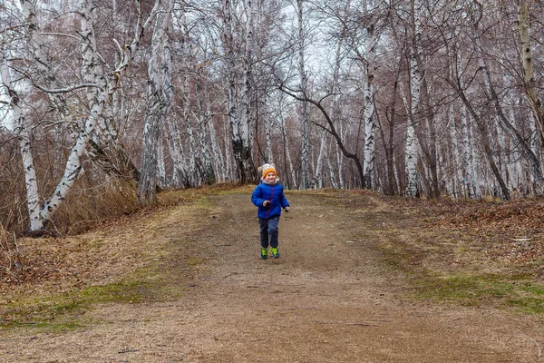 Niño de cinco años con ropa de abrigo corre —  Fotos de Stock