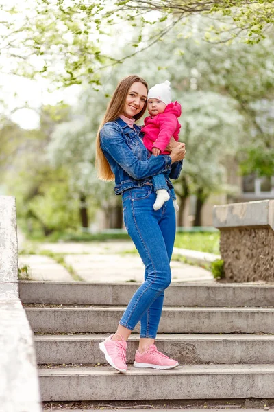Ung Leende Kvinna Denim Kostym Håller Baby Flicka Utomhus — Stockfoto