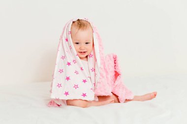 Pembe ekoseli bebek yatakta oturuyor.