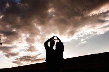 Gün batımında bir adam ve bir kız. Kalp kontrolden çıktı.