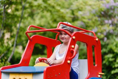 Yazın yedi yaşında bir çocuk tahta bir çocuk arabasında oturur. Bulanık arkaplan