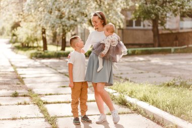 Gülümseyen otuz yaşındaki kadın küçük kızı kollarına aldı ve yedi yaşındaki oğluna sarıldı.