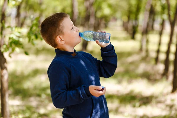 赤ちゃんは屋外でペットボトルから水を飲む — ストック写真