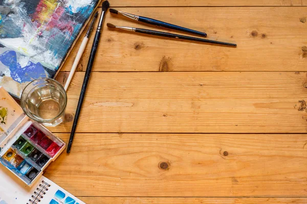 The artist\'s tools on a wooden table.