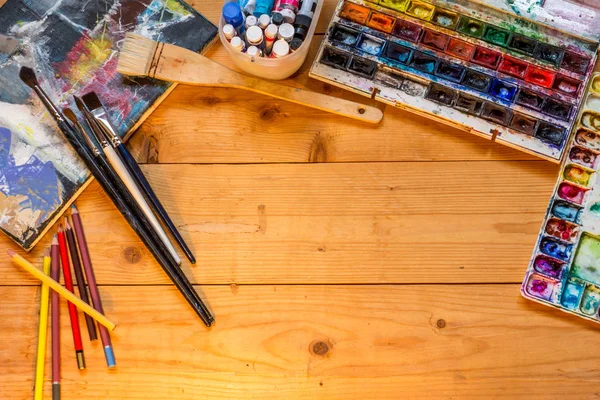 The artist\'s tools on a wooden table.