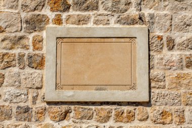 Taştan bir duvar üzerinde boş bir taş tablet.