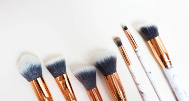 Beyaz arkaplandaki mermer izlerinin makyajı için fırçalar