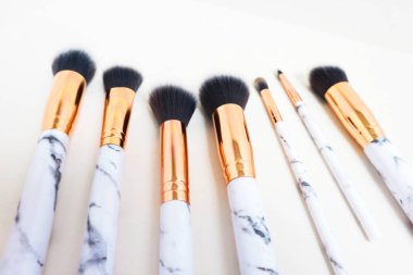 Beyaz arkaplandaki mermer izlerinin makyajı için fırçalar