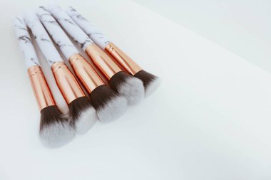 Beyaz arkaplandaki mermer izlerinin makyajı için fırçalar