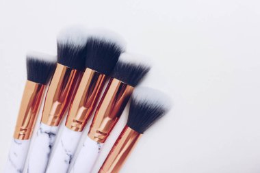 Beyaz arkaplandaki mermer izlerinin makyajı için fırçalar
