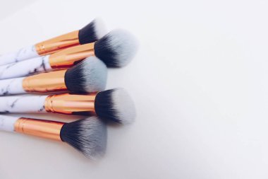 Beyaz arkaplandaki mermer izlerinin makyajı için fırçalar