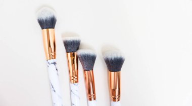 Beyaz arkaplandaki mermer izlerinin makyajı için fırçalar