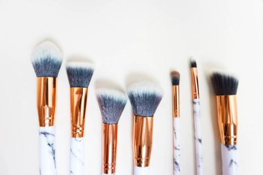 Beyaz arkaplandaki mermer izlerinin makyajı için fırçalar