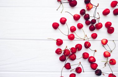 Beyaz ahşap arka planda bir sürü kiraz