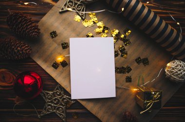 Yılbaşı arkaplanında kağıt ve noel süslemeleri olan temiz kart