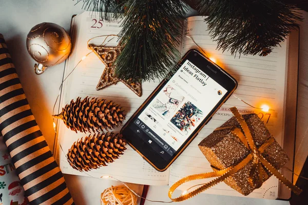 Not defterinde çam kozalakları ve noel ağacı olan telefon.