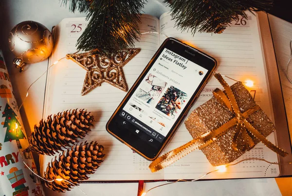 Not defterinde çam kozalakları ve noel ağacı olan telefon.