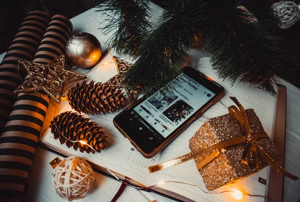 Not defterinde çam kozalakları ve noel ağacı olan telefon.