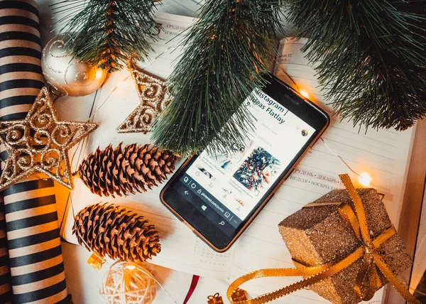 Not defterinde çam kozalakları ve noel ağacı olan telefon.