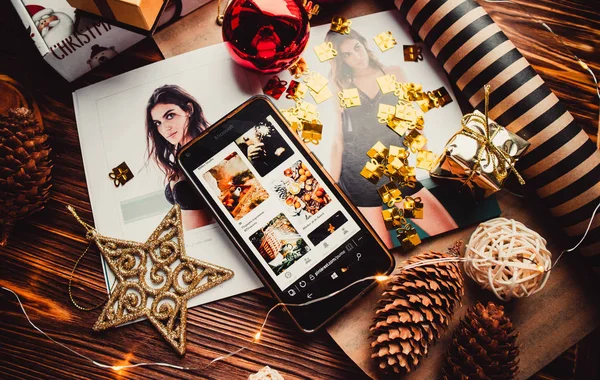 Çam kozalaklı telefon ve ahşap arka planda noel süslemeleri